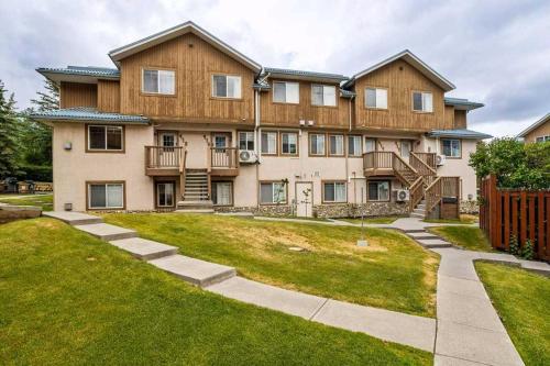 a large house with a lawn in front of it at Entire Lovely Townhouse Mountain View! in Canmore