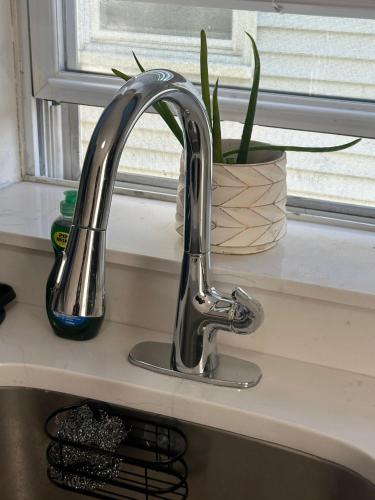 a sink with a faucet next to a window at Genevieves lovely suite in Jersey City