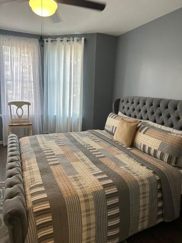 a bedroom with a large bed with a blanket at Genevieves lovely suite in Jersey City