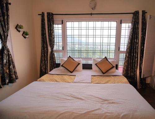 a bedroom with a large bed with a large window at Kainchi Premium Homestay 4BHk in Bhowāli