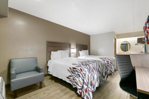 a hotel room with a bed and a chair at Red Roof Inn Washington DC - Laurel in Laurel
