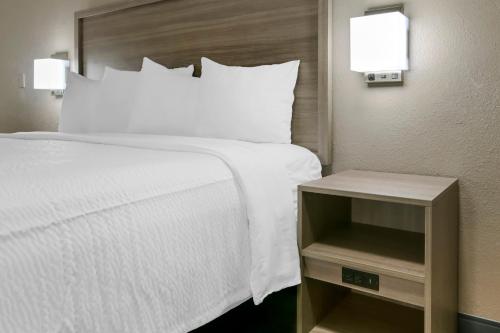 a hotel room with a bed and a night stand at Red Roof Inn Washington DC - Laurel in Laurel