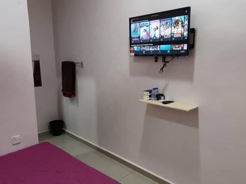 a room with a flat screen tv on a white wall at ZamNur Bidara Chalet dan Homestay in Masjid Tanah