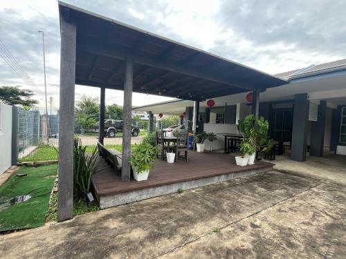 a porch with a blue roof with plants on it at Jo's in Miri