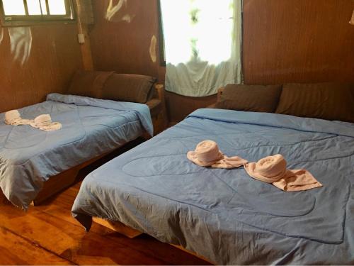 two beds with hats on them in a room at Mukakee 3-4 in Ban Sop Mae Klang