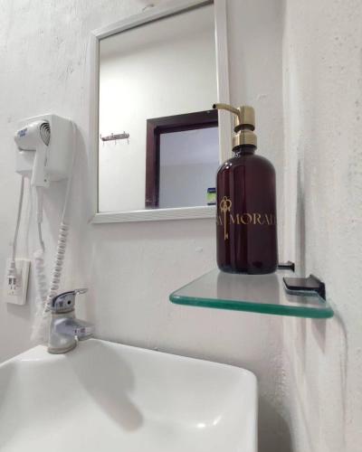 a bottle of soap is sitting on a shelf above a sink at Hostal Casa Morada in Cocula