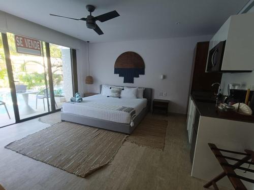 a bedroom with a bed and a ceiling fan at luxury central park lagunas in Tulum