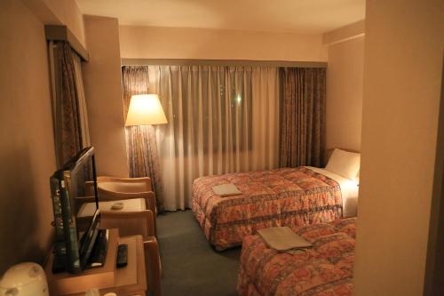 a hotel room with two beds and a television at ホテルパレスイン豊田 in Toyota