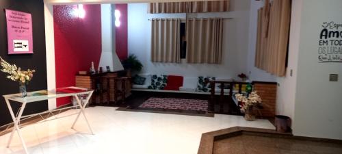 a living room with a table and a red wall at Hostel Blaese Pascal - HBP in Guarulhos