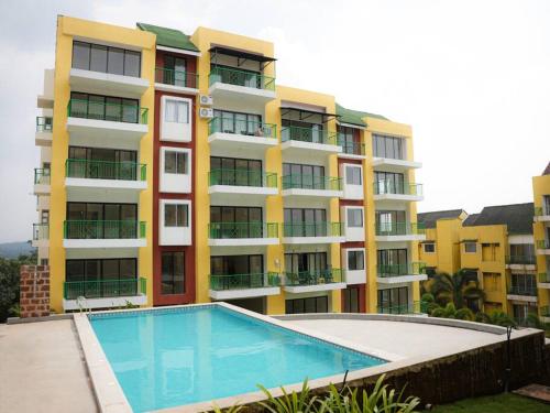 a large apartment building with a swimming pool in front of it at Kudrats Nook -Seaview Bohemian Studio in Canacona
