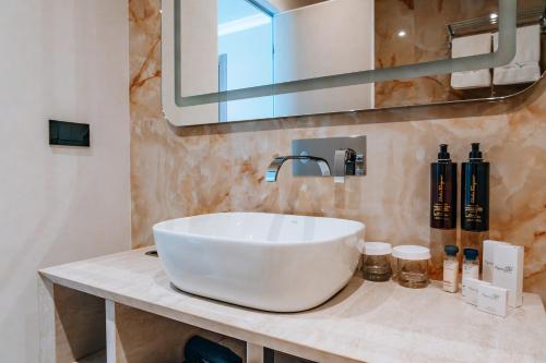 a bathroom with a white sink and a mirror at Sky Airport Hotel in Cluj-Napoca
