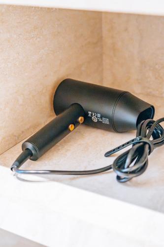a black hair dryer sitting on a counter at Sky Airport Hotel in Cluj-Napoca