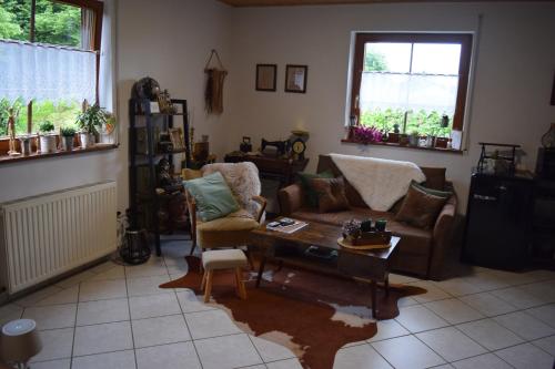 a living room with a couch and a table at Ferienwohnung in der Vulkaneifel "Opp der Holl" in Brockscheid