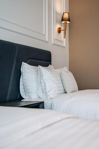 two beds with white sheets and a blue headboard at Sky Airport Hotel in Cluj-Napoca