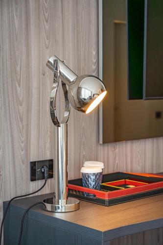 a silver lamp on a counter in a bathroom at Sky Airport Hotel in Cluj-Napoca