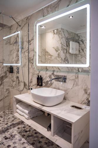 a bathroom with a white sink and a mirror at Sky Airport Hotel in Cluj-Napoca