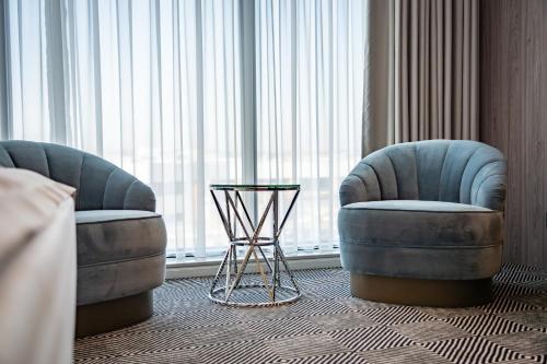 two chairs and a table in a hotel room at Sky Airport Hotel in Cluj-Napoca