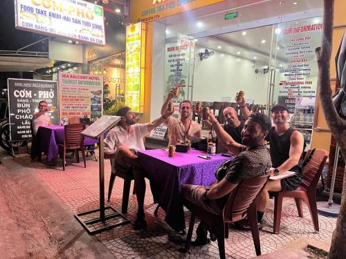 a group of people sitting at a table in a restaurant at Sea Balcony Hotel in Cat Ba