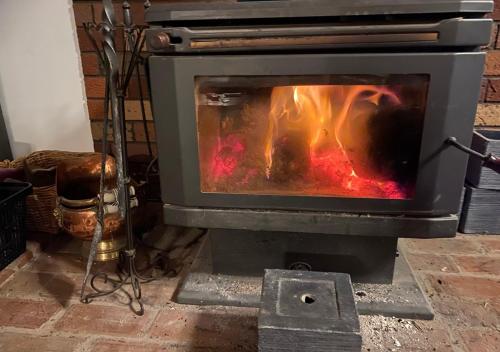 piec z ogniem wewnątrz w obiekcie Bells Beach Spacious 2-Acre 5BR Retreat - with Hot Tub w mieście Bellbrae