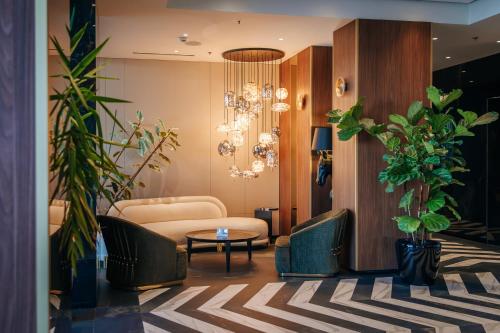 a lobby with a couch and a table and plants at Sky Airport Hotel in Cluj-Napoca
