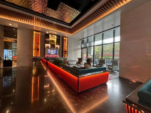 a lobby with a red couch in a room at Facestyle Infinity Pool KLCC Smart TV Free WiFi Two Bedroom in Kuala Lumpur