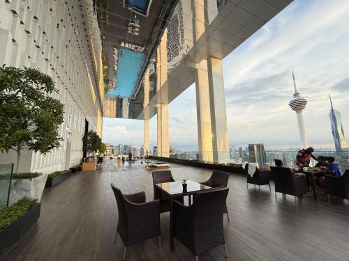 a restaurant with tables and chairs in a building at Facestyle Infinity Pool KLCC Smart TV Free WiFi Two Bedroom in Kuala Lumpur