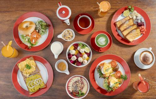 una mesa con platos rojos de comida. en Onederz Siem Reap, en Siem Reap