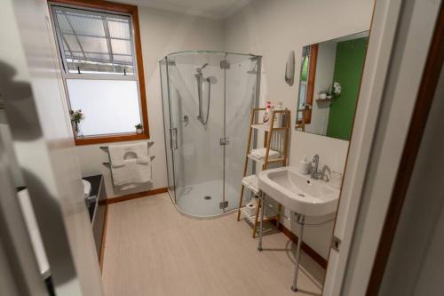 a bathroom with a shower and a sink at Hilltop Escape - Spa & Views in Greymouth