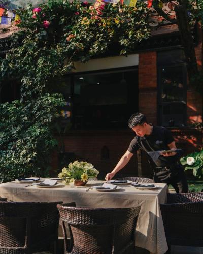 a man standing at a table with a table cloth at Dalai-La Boutique Hotel in Kathmandu