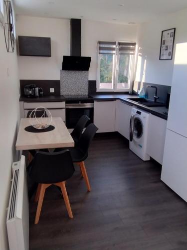 une cuisine avec une table et des chaises dans une cuisine dans l'établissement Le 4G Home Plain-pied #2Chb-3lits #Terrasse #Parking Securisé, à Crépand