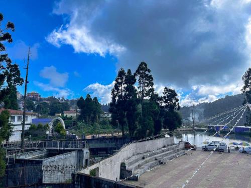a bridge over a river with cars parked in a parking lot at Rise And Shine Homestay in Mirik