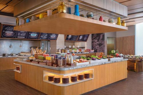 a restaurant with a counter with food on it at Four Points by Sheraton Surabaya, Tunjungan Plaza in Surabaya