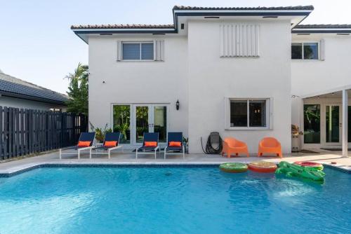 a swimming pool with chairs and a house at 4 Bed 3 Bath Miami Getaway in Miami