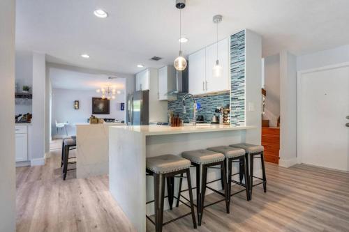 a kitchen with a counter and stools in a room at 4 Bed 3 Bath Miami Getaway in Miami