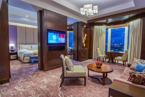a hotel room with a king bed and a living room at Diamond Hotel Philippines in Manila