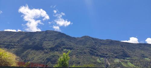 a mountain with a blue sky and clouds on it at Ti coin panoramique in Salazie