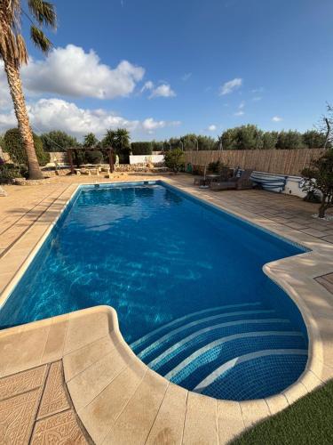 a swimming pool with blue water in a yard at Casa Mica in Albox