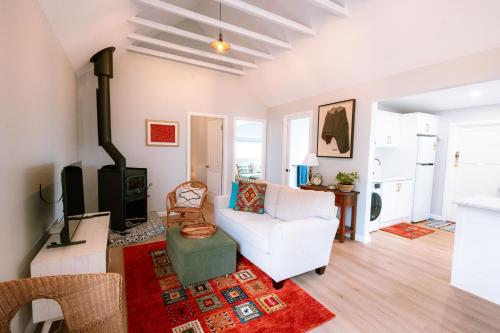 a living room with a white couch and a fireplace at Newly Renovated 100 Year Old Bliss Cottage - Adaline in Katoomba