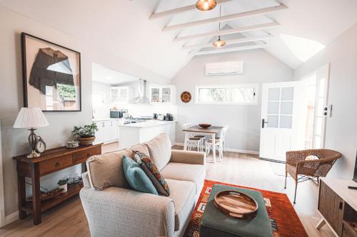 a living room with a couch and a kitchen at Newly Renovated 100 Year Old Bliss Cottage - Adaline in Katoomba