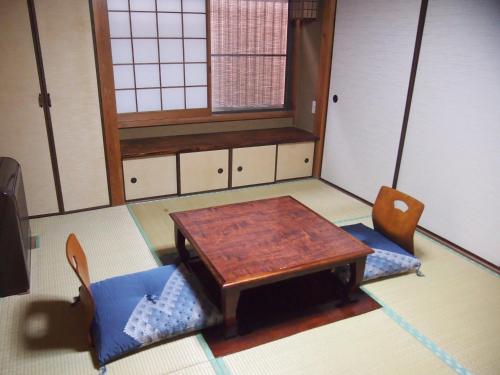 a room with a wooden table and two chairs at ICHIE Second Location in Tanabe