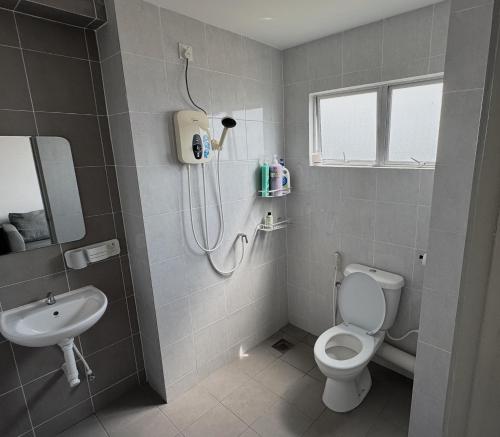 um banheiro com chuveiro, vaso sanitário e pia em Coziness Suite with high speed WiFi dan Netflix em Sitiawan