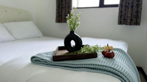 a black vase sitting on top of a bed at Putrajaya Antara Residence Fully Air-Con Suite Facing Beauty Lake View in Putrajaya