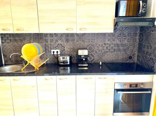 une cuisine avec un évier et un micro-ondes dans l'établissement Toulouse vaste appartement très lumineux, à Toulouse
