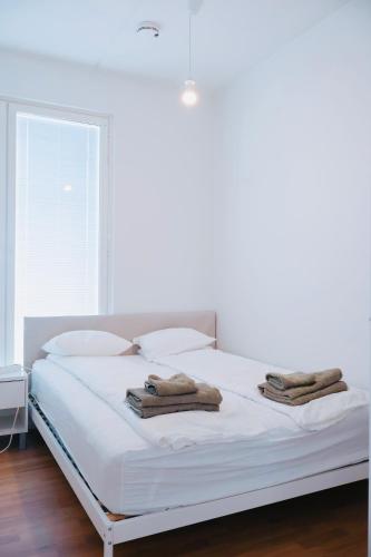 a bedroom with a white bed with towels on it at Modern 2-Bedroom Apartment with Sauna, Forest View & Parking in Espoo