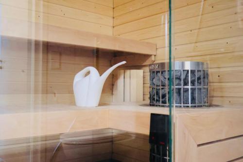 a bathroom with a toilet and a vase on a shelf at Modern 2-Bedroom Apartment with Sauna, Forest View & Parking in Espoo