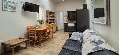 a living room with a couch and a table and a kitchen at The Old House at Belfield in Tralee