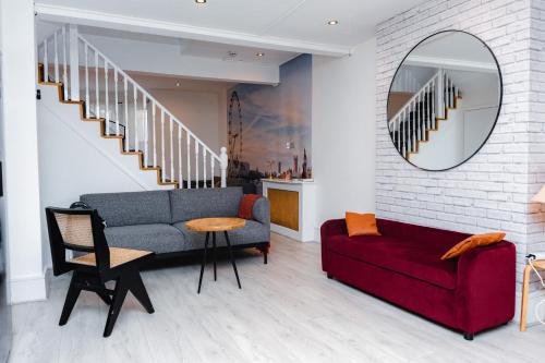 a living room with a red couch and a mirror at HARU Residence, 5bed Luxury House in London
