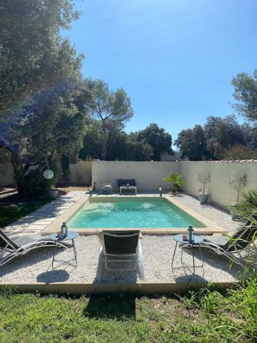 une piscine avec deux chaises et une table dans l'établissement Maison de Vacances en Provence, à Venasque