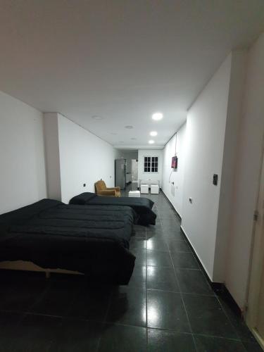 Habitación con 3 camas en una habitación con pasillo en Glam, en Santiago del Estero