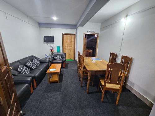 a living room with a couch and a table and chairs at Amaze PY Homestay in Tawang